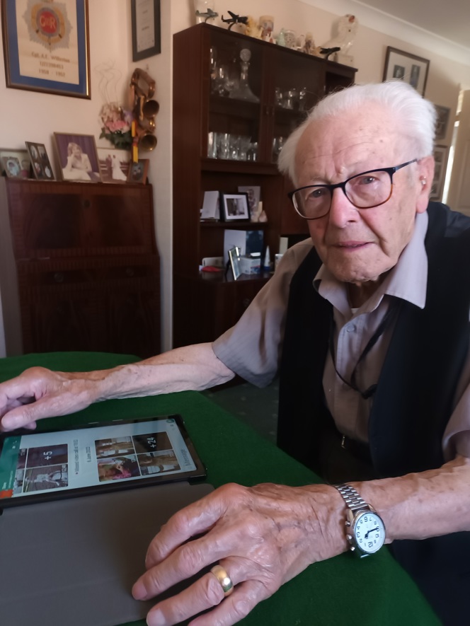Blind veteran Eddie sitting with his tablet looking at photographs