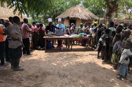 Photo of Malawian home cooks and local head chef Cephus teaching Penny, centre, authentic local cuisine