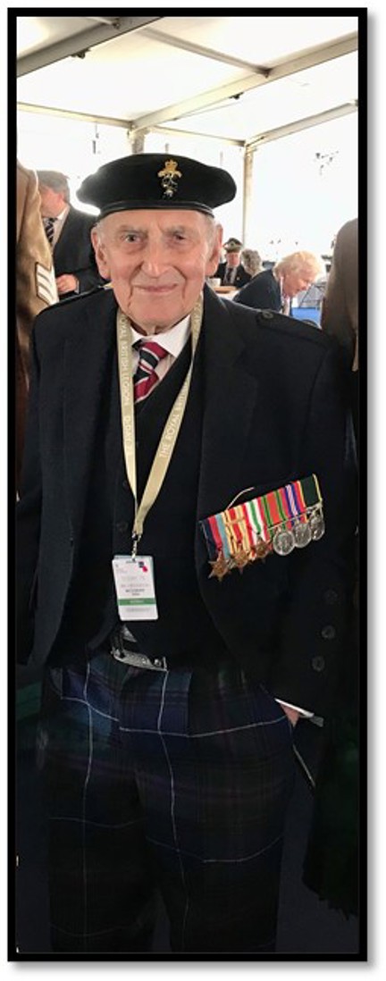 Blind veteran John at an event wearing his beret and military medals