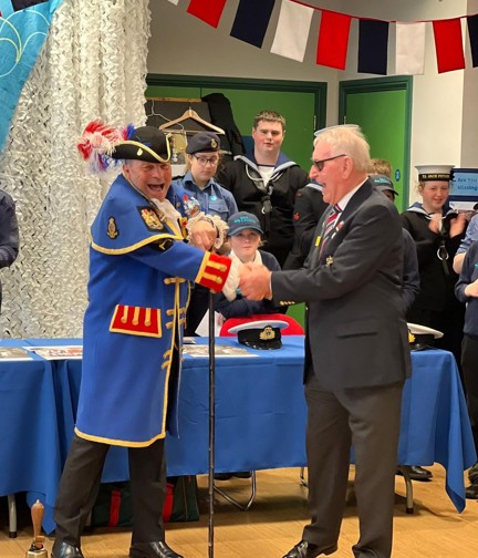 Billy dressed in his town crier robes shaking hands with John 