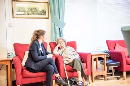 A photo of Stella Savage, a blind veteran talking to Tegwen a volunteers