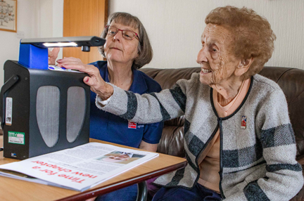 Blind veteran Margaret being trained to use a reader