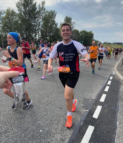 Ryan in action on the race course, smiling as he runs towards the camera.