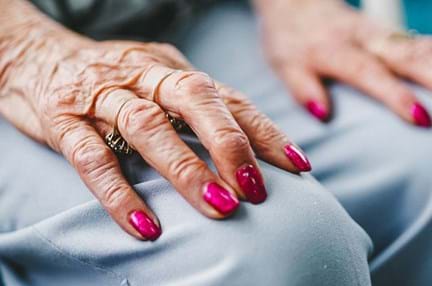 Female blind veteran's hands resting on her lap