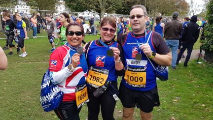 Photo of Joey, left, Angela, centre, and Andy, right holding their medals, wearing Blind Veterans UK vests after finishing the Great South Run in Portsmouth