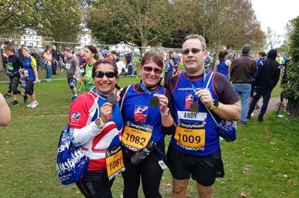 Photo of Joey, left, Angela, centre, and Andy, right holding their medals, wearing Blind Veterans UK vests after finishing the Great South Run in Portsmouth