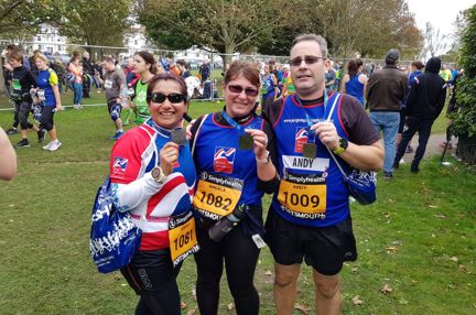 Photo of Joey, left, Angela, centre, and Andy, right holding their medals, wearing Blind Veterans UK vests after finishing the Great South Run in Portsmouth