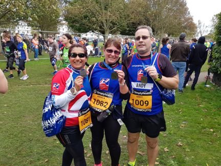 Photo of Joey, left, Angela, centre, and Andy, right holding their medals, wearing Blind Veterans UK vests after finishing the Great South Run in Portsmouth
