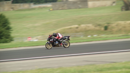 Blind veteran Billy wearing motorbike gear and riding his motorbike along a road