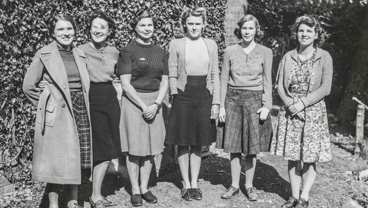 An archive photograph of a blind veteran Barbara standing outside smiling with a group of female blind veterans