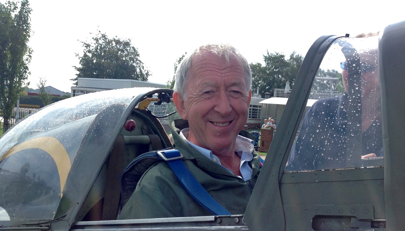 Chris smiling and looking at the camera while sat in an original Second World War Spitfire plane