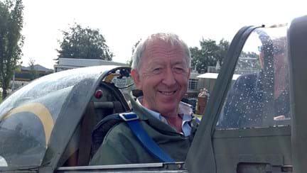 Chris smiling and looking at the camera while sat in an original Second World War Spitfire plane