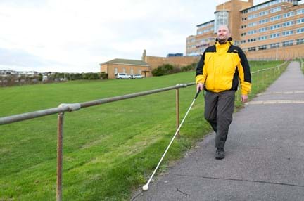 Photo of blind veteran Mark using guide cane