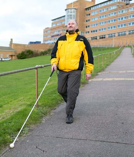 Photo of blind veteran Mark using guide cane