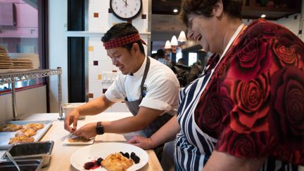 Photo of chef Mack, left, teaching Penny, right, how to make a peach gallete at San Francisco's One Market