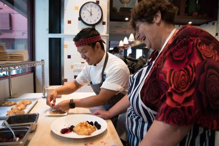 Photo of chef Mack, left, teaching Penny, right, how to make a peach gallete at San Francisco's One Market
