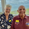 A photo of our Centre Manager, Lesley, left, with blind veteran Alan, right. Both smiling and looking at camera with background overlooking the sea.