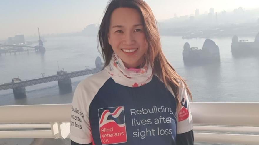 Supporter Roxana stood in front of a misty River Thames wearing her Blind Veterans UK T-shirt 