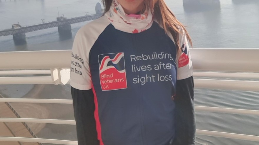 Supporter Roxana stood in front of a misty River Thames wearing her Blind Veterans UK T-shirt 