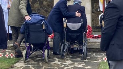 Ken and Nancy at the Rustington War Memorial, Nancy is being helped from her wheelchair by staff member.