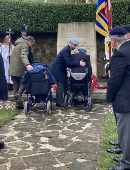 Ken and Nancy at the Rustington War Memorial, Nancy is being helped from her wheelchair by staff member.
