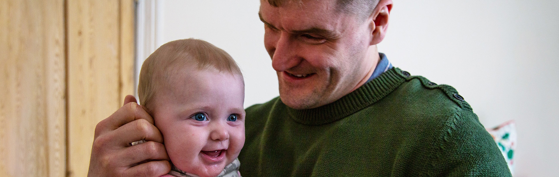 A photo of Rob Long smiling holding his baby girl