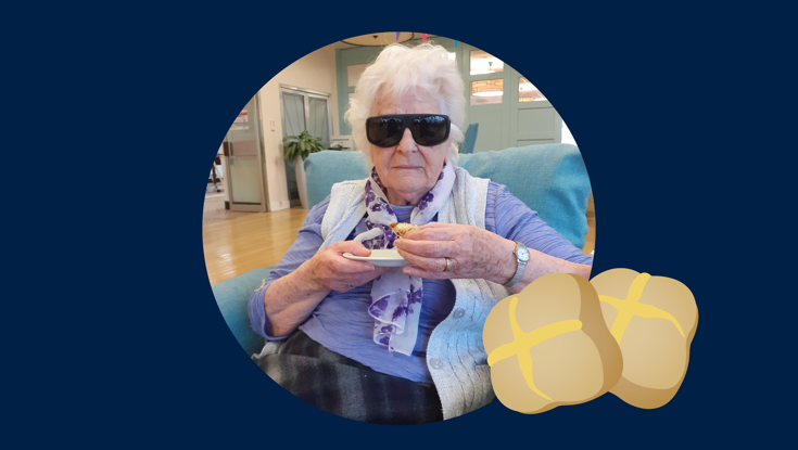 Blind veteran Betty holding a hot cross bun, with an added illustration of a hot cross bun 