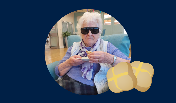 Blind veteran Betty holding a hot cross bun, with an added illustration of a hot cross bun