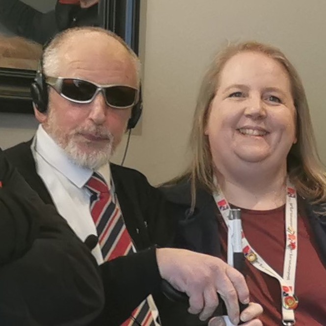 Dean wearing dark glasses with Community support worker Katherine, smiling