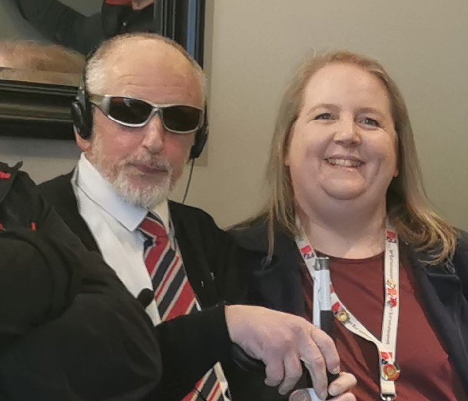 Dean wearing dark glasses with Community support worker Katherine, smiling