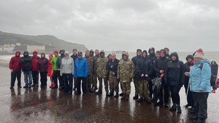 A group 26 students and staff stop for a photo as they make their way from our Llandudno Centre to the Llandudno War Memorial in very wet and windy conditions.
