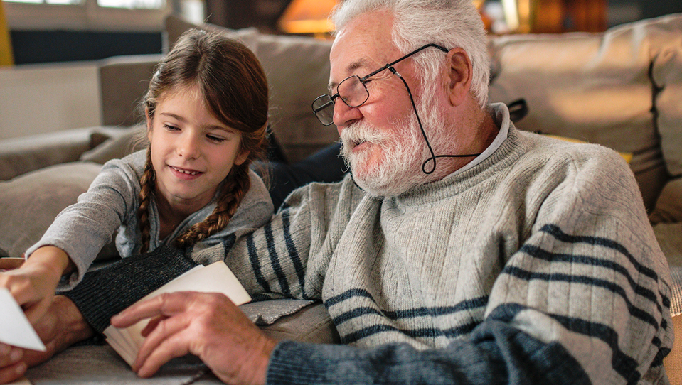 A grandad showing his granddaughter memories from past