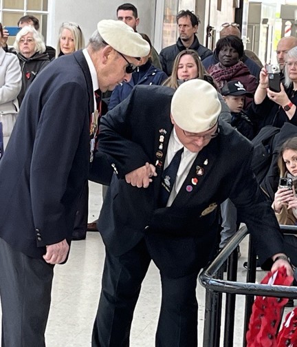 Tony is being assisted to place his wreath at the base of the War Memorial