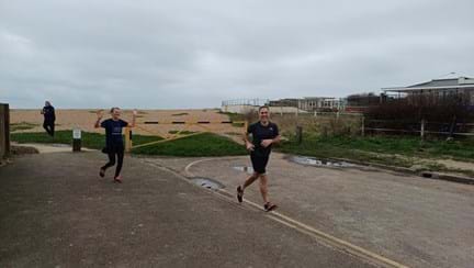 Lynn and Chris running away from the beach at Rustington towards the entrance for the Rustington Centre