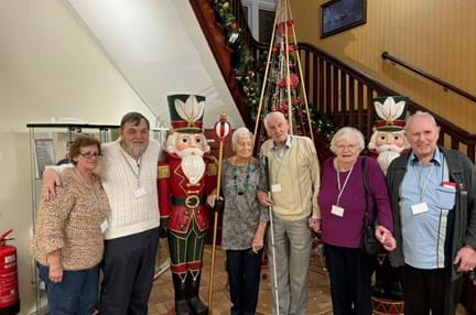 The three couples are stood together at the bottom of the staircase in Llandudno gathered around a nutcracker