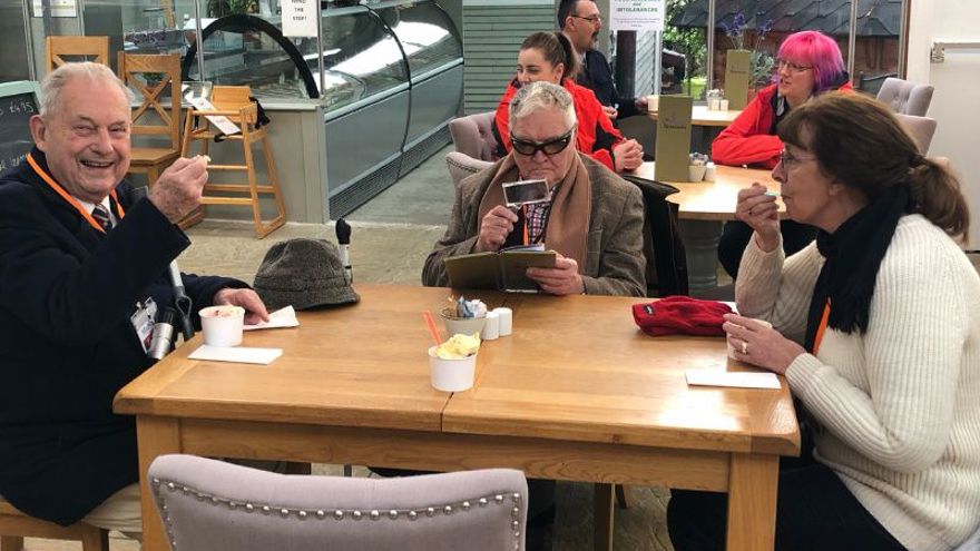 A group of blind veterans eating ice cream 