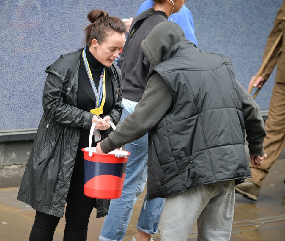 Bucket collection taking a donation for Blind Veterans UK.