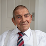 A close up of blind veteran Eddie smiling, wearing a shirt and Blind Veterans UK tie