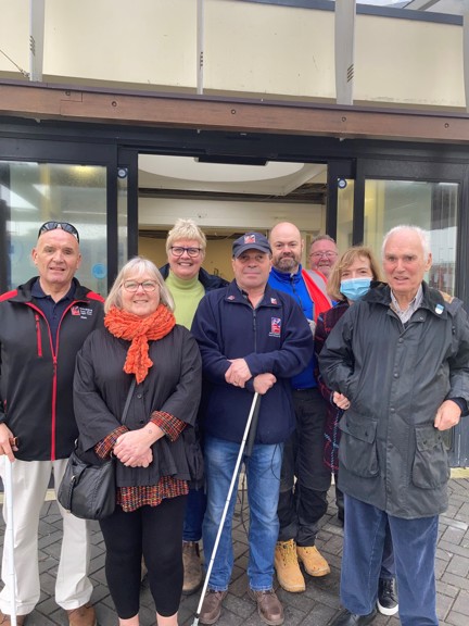 Photo of our Member design group featuring blind veterans and staff pictured outside the new wellbeing centre in Rustington