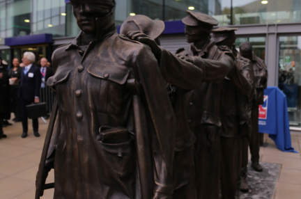 Victory Over Blindness statue depicting seven blinded soldiers leading one another with their hands on their comrades’ shoulders