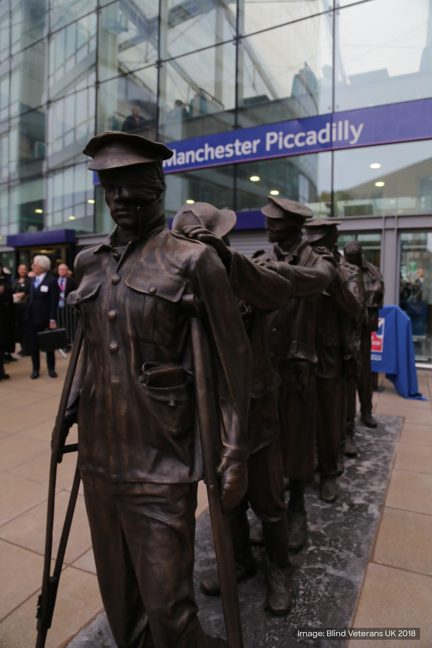 Victory Over Blindness statue depicting seven blinded soldiers leading one another with their hands on their comrades’ shoulders