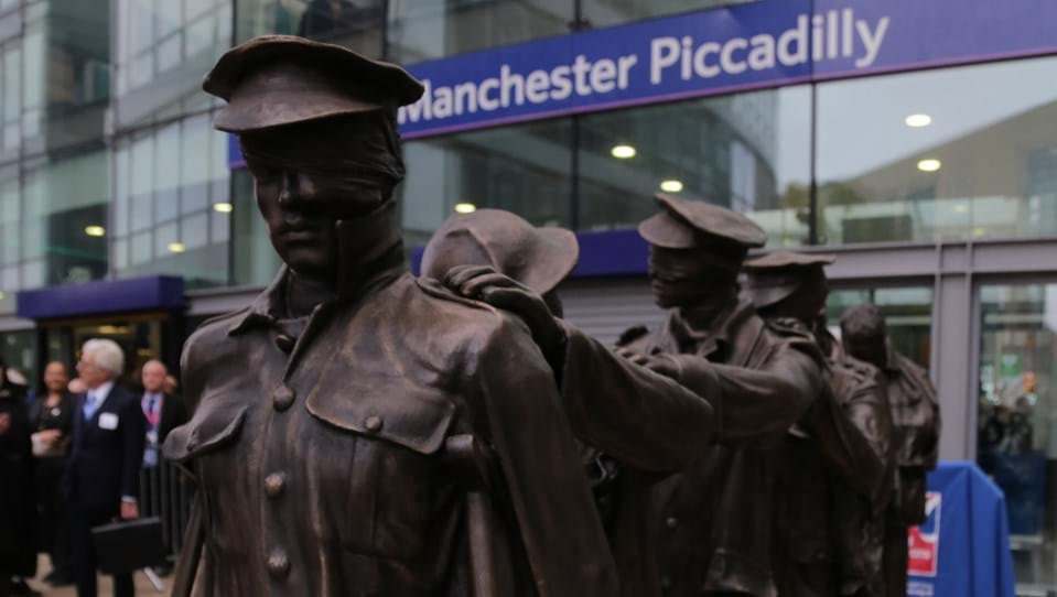 A photo of the Victory Over Blindness statue depicting seven blinded soldiers leading one another with their hands on their comrades’ shoulders