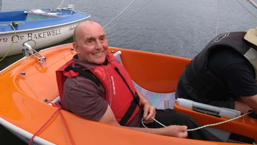 Blind veteran, Simon, smiling and sailing at Carsington Water