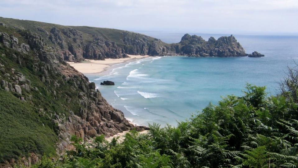 Porthcurno Beach surrounded by high cliffs
