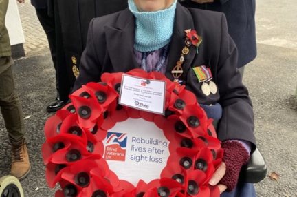 Nancy sat in her wheelchair holding a wreath