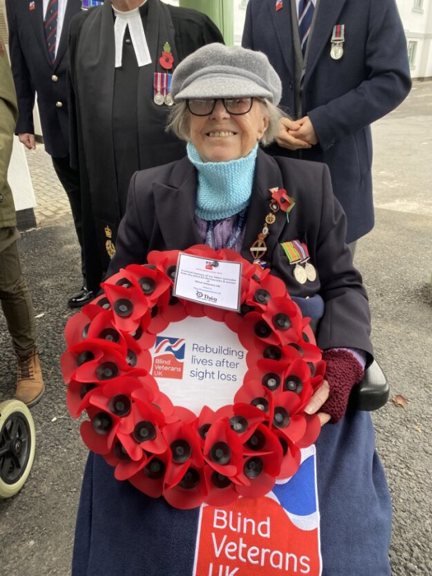Nancy sat in her wheelchair holding a wreath