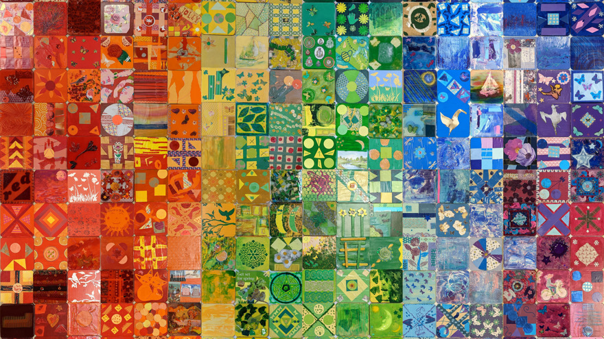 Various colourful designs on small tiles, displayed together to create a rainbow-like collaborative artwork