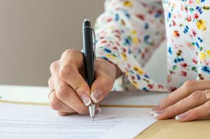 A photo of a Woman signing a document