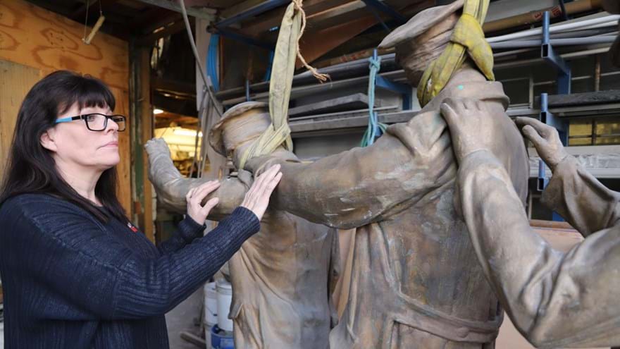 A photo of artist and sculptress Johanna Domke-Guyot with her Victory Over Blindness statue