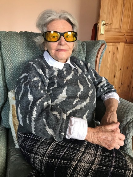 Photograph of blind veteran Neena, photographed at home sitting on an armchair